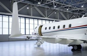 Luxury business jet airplane being stored inside an aviation hangar