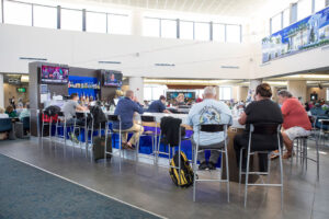 Passengers waiting for their flights to depart are sitting at a bar located in the terminal of Palm Beach International Airport, | Photo: Jodi Jacobson