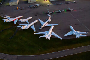 A group of private jets parked on the tarmac