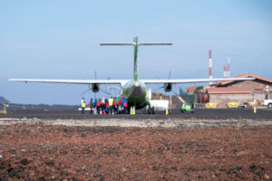 A group of refugees prepares to board a small propeller plane