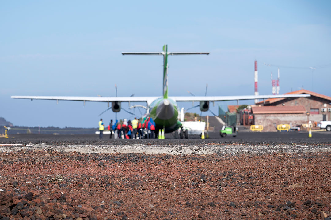 A group of refugees prepares to board a small propeller plane
