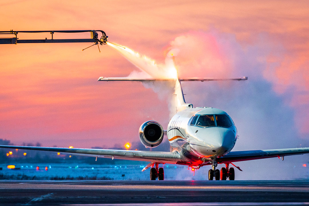 Deicing application to a private jet's tail.