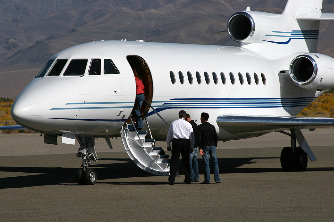 Passengers boarding a large cabin private jet on airport runway