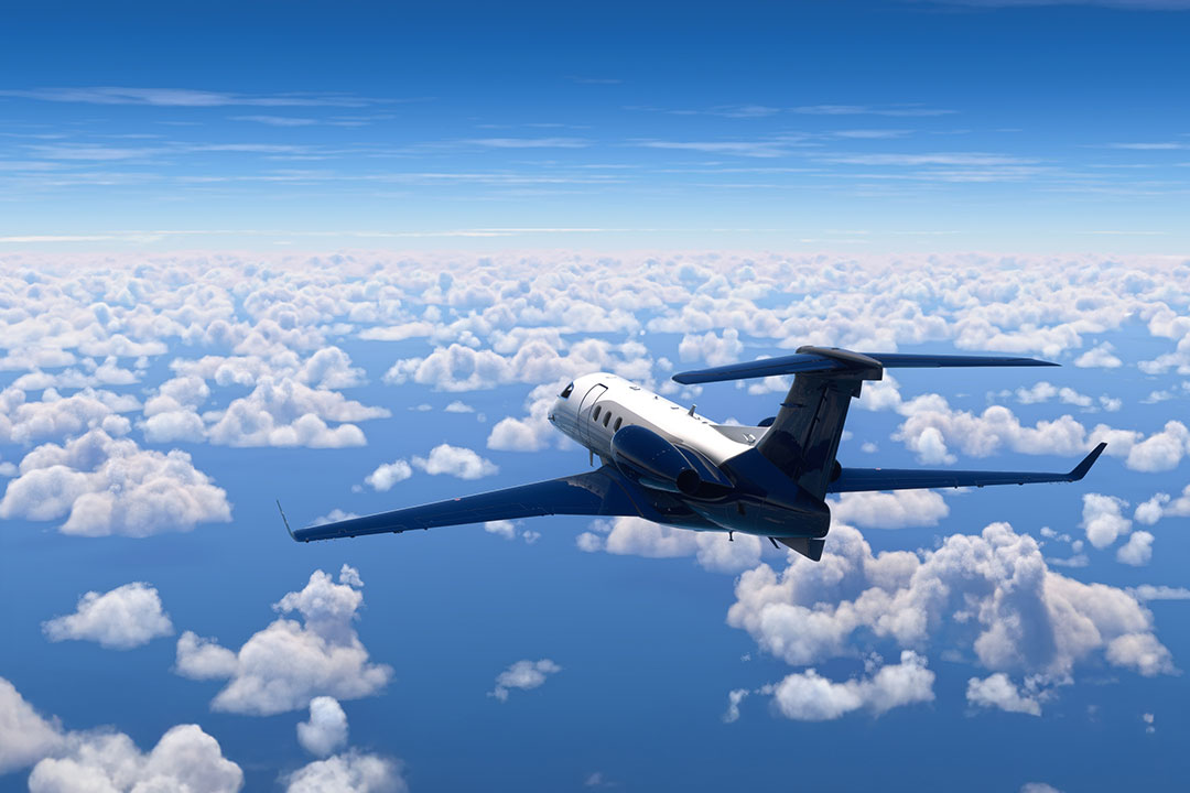A private light jet soars above the clouds.