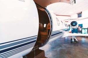 A private jet with an open door while its parked in a private jet hangar.
